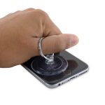 آیفون 6 اس تعمیری را روی میز کارتان قرار دهید. دست خود را روی نمایشگر گوشی تکیه داده و با انگشت گیره ساکشن کاپ را بگیرید. به آرامی ساکشن کاپ را به سمت بالا بکشید و با انتهای دستتان از بلند شدن بدنه گوشی جلوگیری کنید.