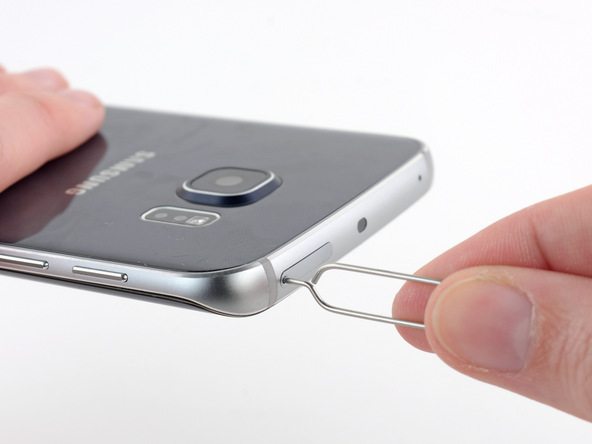 سوزن باز کننده خشاب سیم کارت گلکسی S6 Edge را در مجرای باریکی فرو کنید که روی لبه فوقانی قاب این گوشی موجود است.