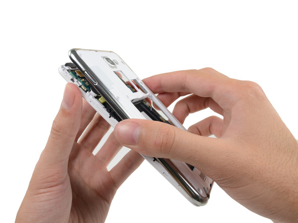 به آرامی فریم میانی گلکسی نوت تعمیری را با دست گرفته و از روی بدنه گوشی جدا کنید. برای انجام این کار گوشی را مثل عکس اول در دستتان بگیرید.
