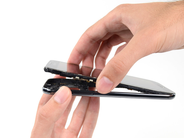 گلکسی نوت 2 تعمیری را به گونه‌ای در دستتان بگیرید که فریم میانی گوشی رو به سمت پایین قرار بگیرد و صفحه نمایش آن رو به سمت بالا قرار داشته باشد.
