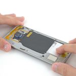 روی بدنه اصلی Galaxy S6 Edge یک فریم پلاستیکی قرار دارد که اصطلاحا به آن فریم میانی (Mid-Frame) گفته می‌شود. مثل عکس اول گلکسی اس 6 اج تعمیری را روی یک سطح صاف قرار داده و با انگشتان شصت خود دو گوشه فریم را بگیرید.