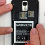 گوشی Galaxy S2 T989 تعمیری را روی میز کارتان قرار دهید و با ناخن یا نوک اسپاتول لبه زیرین باتری را از روی بدنه گوشی بلند کنید.