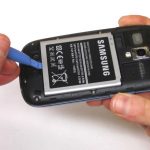 نوک قاب باز کن پلاستیکی را در بخش زیرین باتری Galaxy S3 Mini تعمیری فرو برده و باتری را به سمت بالا هول دهید و کامل از بدنه گوشی جدا کنید.