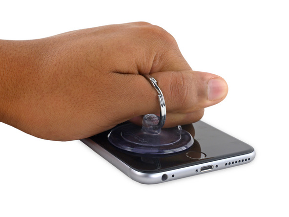 آیفون 6S Plus تعمیری را روی میز کارتان قرار دهید. دست خود را روی نمایشگر گوشی قرار داده و فشار دهید تا از جابجا شدن آیفون جلوگیری شود.