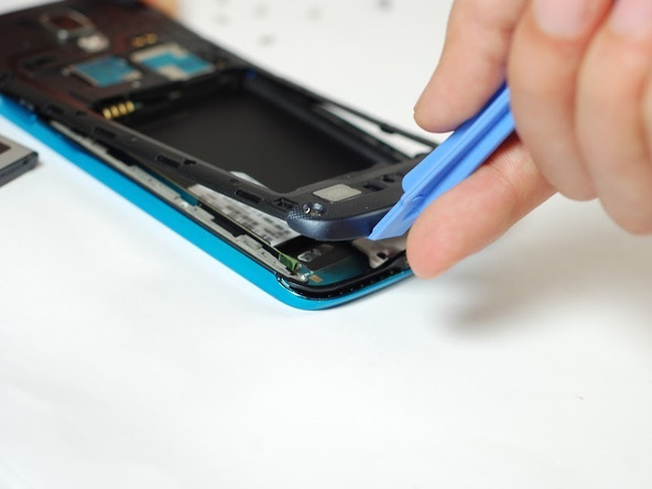 لبه زیرین فریم پلاستیکی روی بدنه Galaxy S4 Active تعمیری یا اصطلاحا فریم میانی این گوشی را با نوک قاب باز کن گرفته و به سمت بالا بکشید تا از روی بدنه گوشی بلند شود.