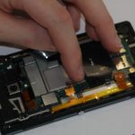 چسب NFC که روی فریم فلزی مادربرد سونی اکسپریا ZL نصب است را خیلی آرام و با دقت از روی آن جدا کنید.