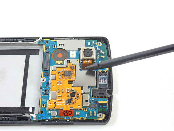 نوک اسپاتول را زیر کانکتور لنز دوربین اصلی Nexus 5 تعمیری قرار دهید و خیلی آرام آن را به سمت بالا هدایت کنید تا کانکتور مذکور از روی مادربرد گوشی آزاد شود.