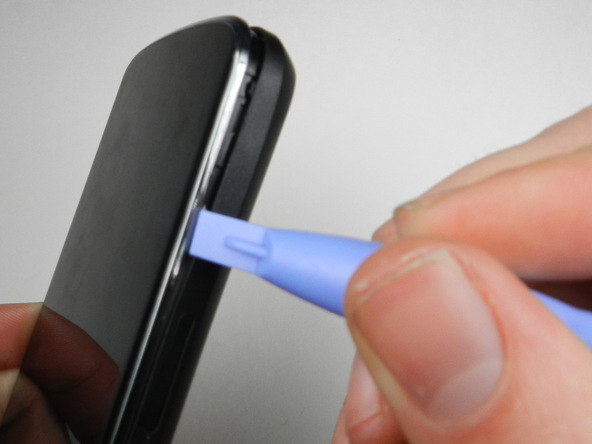 نوک قاب باز کن پلاستیکی را به آرامی از گوشه قاب Nexus 4 به داخل شکاف مابین درب پشت و بدنه اصلی آن فرو ببرید.