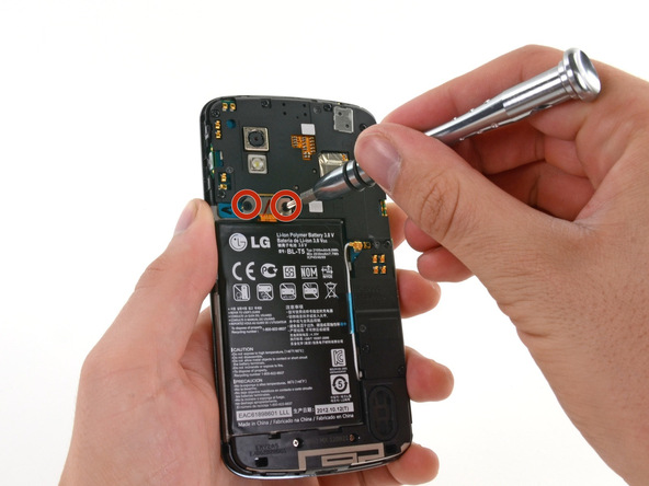 دو پیچ 1.8 میلیمتری که در عکس اول نشان داده شده‌اند را باز کنید تا براکت روی کانکتور باتری Nexus 4 تعمیری آزاد شود.