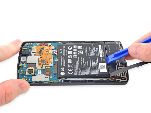 به آرامی با اسپاتول یا قاب باز کن لبه زیرین باتری Nexus 5 تعمیری را از روی جایگاهش بلند کنید.